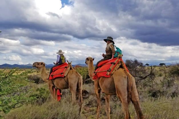 Patti riding a camel on safari in Kenya